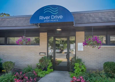 river drive apartment community building, front door hero